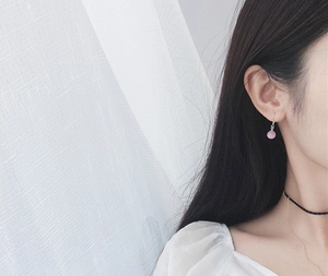 Detail of a long S925 sterling silver hook earring with a round pink cat eye stone bead