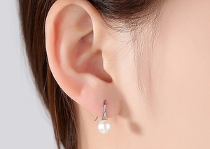 Close-up of elegant S925 silver shell pearl earring worn by model in a soft profile view