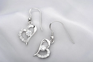 Detail of S925 sterling silver heart earrings with sparkling cubic zirconia inlay