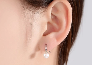 Detailed view of S925 silver pearl drop earrings worn to highlight its elegant luster