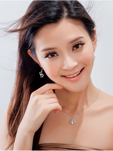 Close-up of elegant S925 sterling silver heart-shaped necklace and earring set on model
