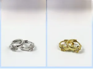 Dettaglio di orecchini a stella in argento e oro con cristalli scintillanti per donne