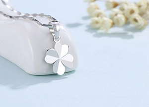 Detailed macro view of S925 sterling silver four-leaf clover pendant with faceted texture
