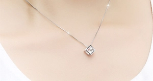 Gros plan du collier cube en argent sterling S925 sur la clavicule de la femme