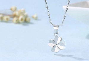 Macro shot of silver four-leaf clover pendant necklace with a polished mirror finish