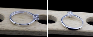 Detailed view of silver six-prong moissanite ring with adjustable open band design