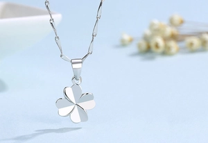 Close-up of a polished S925 sterling silver four-leaf clover pendant on a delicate chain