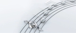 Macro shot of silver pendant with clear zircon on a creative music sheet background