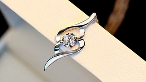 Macro detail of S925 sterling silver swirl pendant with brilliant round diamond setting