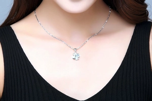 Close-up of S925 sterling silver four-leaf clover pendant necklace on a female neck