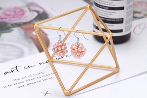 Detailed macro view of pinkish-purple irregular freshwater pearl cluster earrings hanging