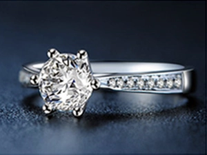 Macro side view of a classic six-prong solitaire ring with side diamond accents