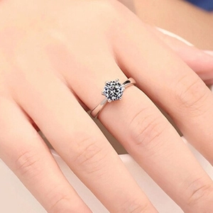 Detailed close-up of a classic six-prong crown setting S925 silver ring on a female finger