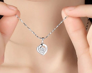 Detail of S925 silver heart necklace with zircon pendant on twisted water wave chain