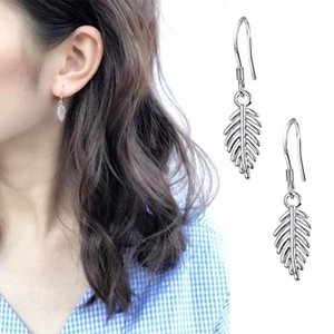 Détails des boucles d'oreilles feuilles en argent S925 avec textures plumes sur le mannequin