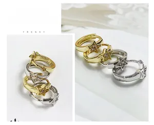 Dettaglio di orecchini a stella con intarsio in zircone nelle finiture oro e argento