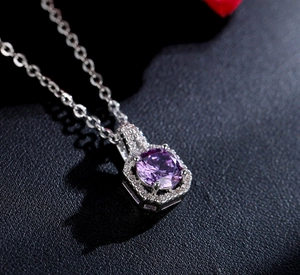 Gros plan du pendentif en argent avec améthyste violette et serti halo octogonal