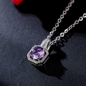 Vue macro du pendentif hexagonal en argent avec un grand zircon violet et de petits diamants pavés