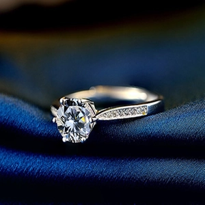 Classic 1 carat six-prong S925 sterling silver diamond ring on navy blue silk background