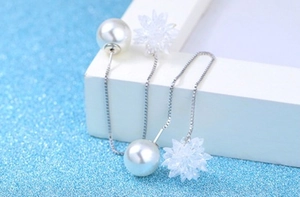Macro view of sterling silver chain earring with large pearl and crystal flower detail