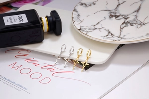 Detailed view of S925 sterling silver star dangle earrings in gold and silver finish