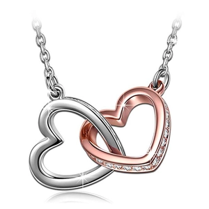 Close-up of interlocking silver and rose gold heart pendant with crystal stones