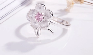 Macro detail of S925 silver cherry blossom ring with pink crystal center stone