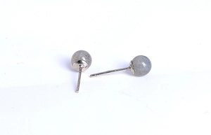 Macro detail of natural labradorite silver stud earrings with blue texture on white background
