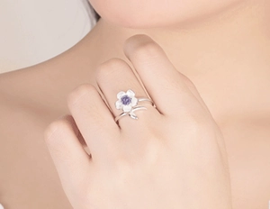 Close-up of S925 silver cherry blossom ring with purple diamond inlay on female finger