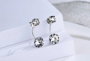 Macro shot of silver stud earrings featuring layered clear cubic zirconia stones