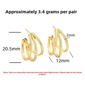 Detailed view of polished gold plated triple hoop earrings with geometric layered design