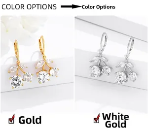 Close-up of cherry drop earrings with sparkling cubic zirconia in gold and silver finish