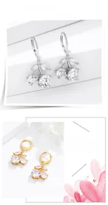 Detailed view of sparkling cubic zirconia cherry earrings in silver and gold finishes