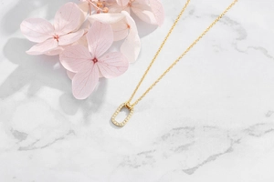 Close-up of gold geometric pendant with pavé cubic zirconia on an O-chain necklace