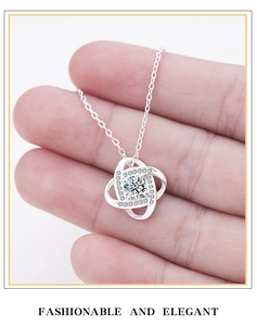 Detail of silver love knot pendant with central round-cut stone and pavé accents