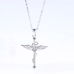 Detalle del colgante de cruz ángel en plata 925 con piedra de circón en forma de corazón