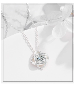 Macro detail of 925 sterling silver infinity knot pendant with sparkling cubic zirconia