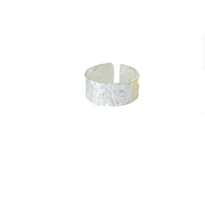 Détail d'une bague large en argent 925 avec texture de vagues irrégulières et fini martelé