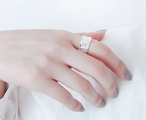 Gros plan d'une bague vague en argent 925 avec texture martelée sur le doigt d'un modèle
