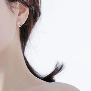 Detailed close-up of 925 sterling silver flower earrings worn on a female ear model