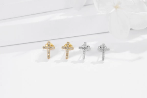Detail of silver and gold cross stud earrings with sparkling cubic zirconia stones