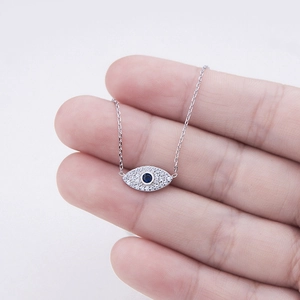 S925 silver Evil Eye pendant necklace with blue stones and crystals held by hand