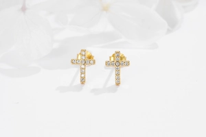 Detail shot of gold S925 silver cross stud earrings with sparkling pave zircon settings