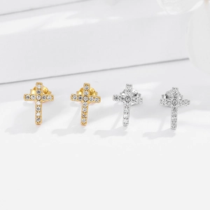 Detailed view of silver and gold cross stud earrings with sparkling zircon inlay
