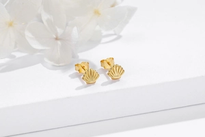 Nahaufnahme goldener Muschelstecker mit S925-Stempel auf weißem Displayständer