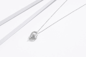 Detail of S925 sterling silver heart necklace with crystal stones and intricate engraving