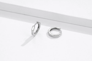 Macro shot of silver octagonal hoop earrings featuring S925 hallmark and polished finish