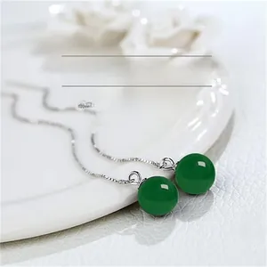 Macro shot of 925 silver tassel earrings featuring polished green agate round beads