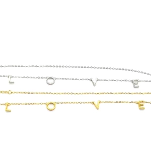 Vue détaillée des pendentifs LOVE en argent S925 avec finitions dorées et argentées