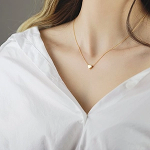 Elegante goldene Herzanhänger Halskette für Damen auf minimalistischem weißem Hemd